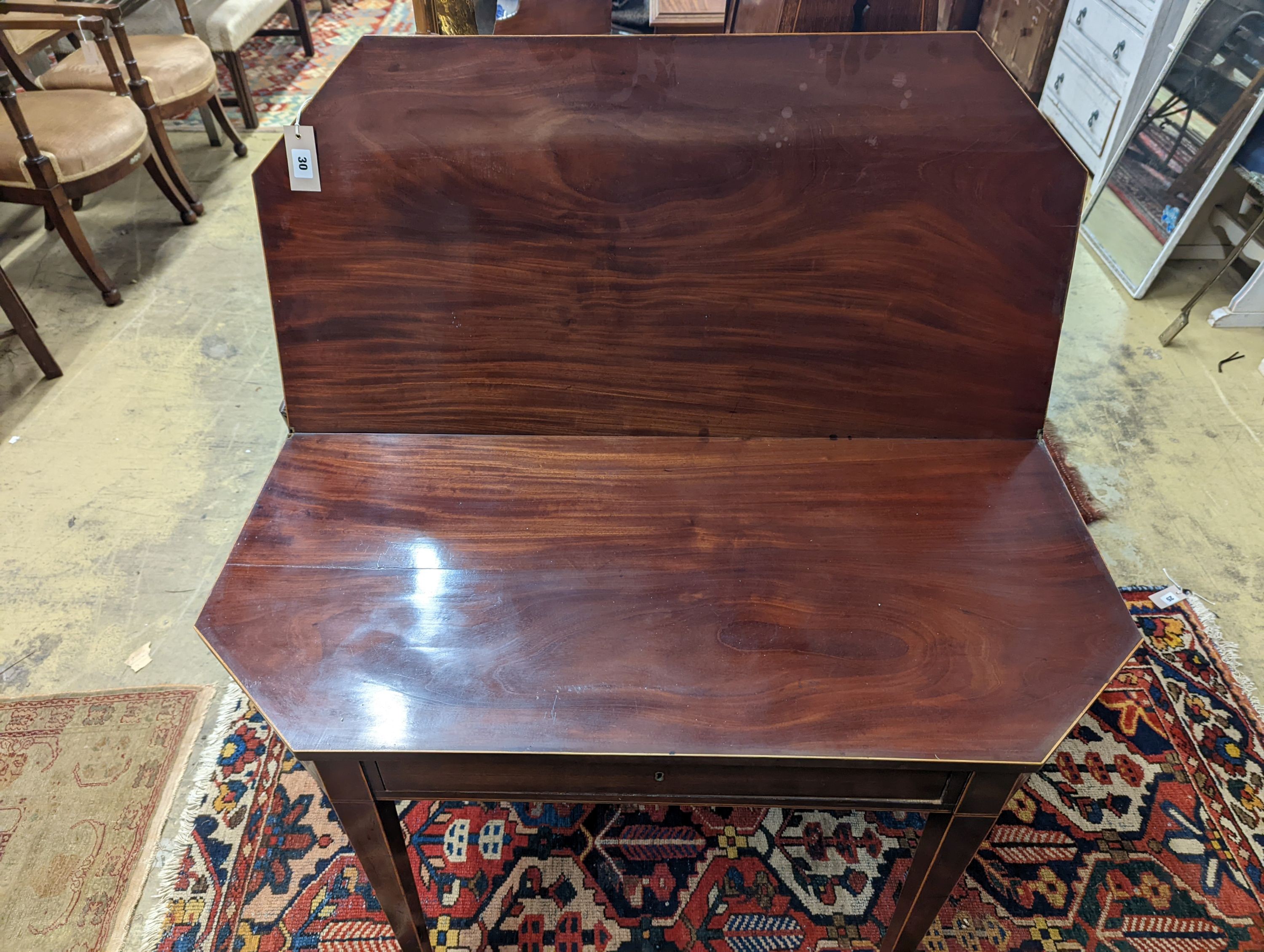 A George III faded mahogany folding tea table, width 97cm, depth 47cm, height 75cm